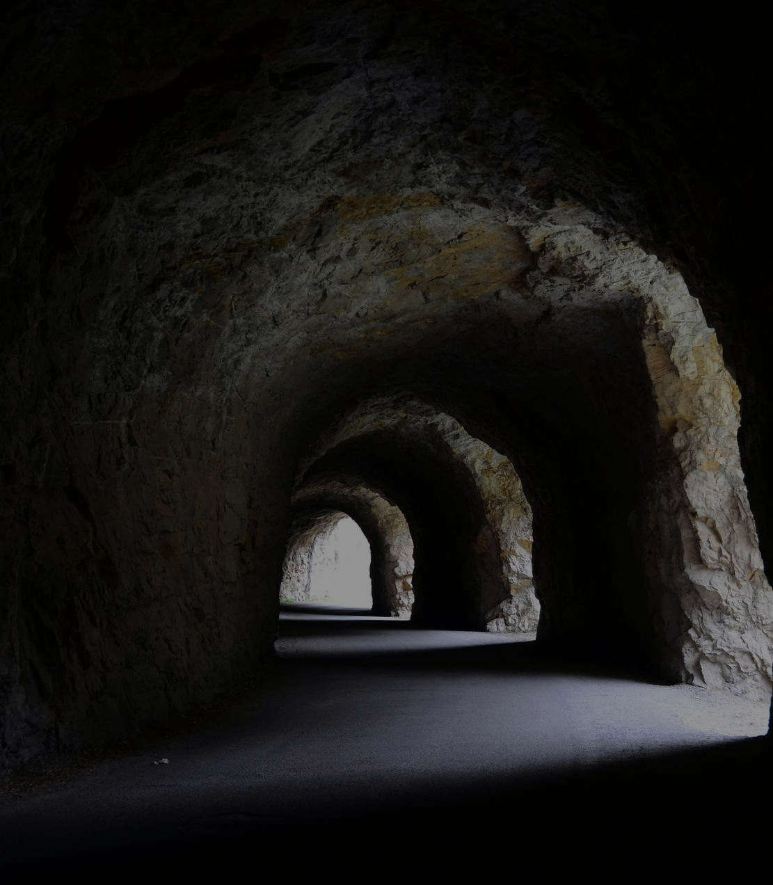 Corridoio sotterraneo con illuminazione fioca, evocativo di un rifugio della Seconda Guerra Mondiale