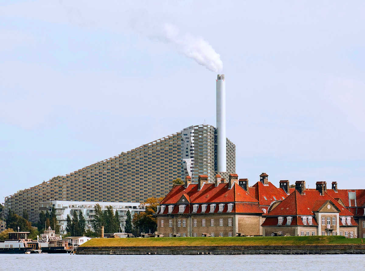 Pista da sci artificiale su un edificio moderno con vista sulla città, CopenHill